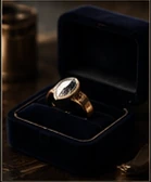 A gold ring waiting in a navy velvet box